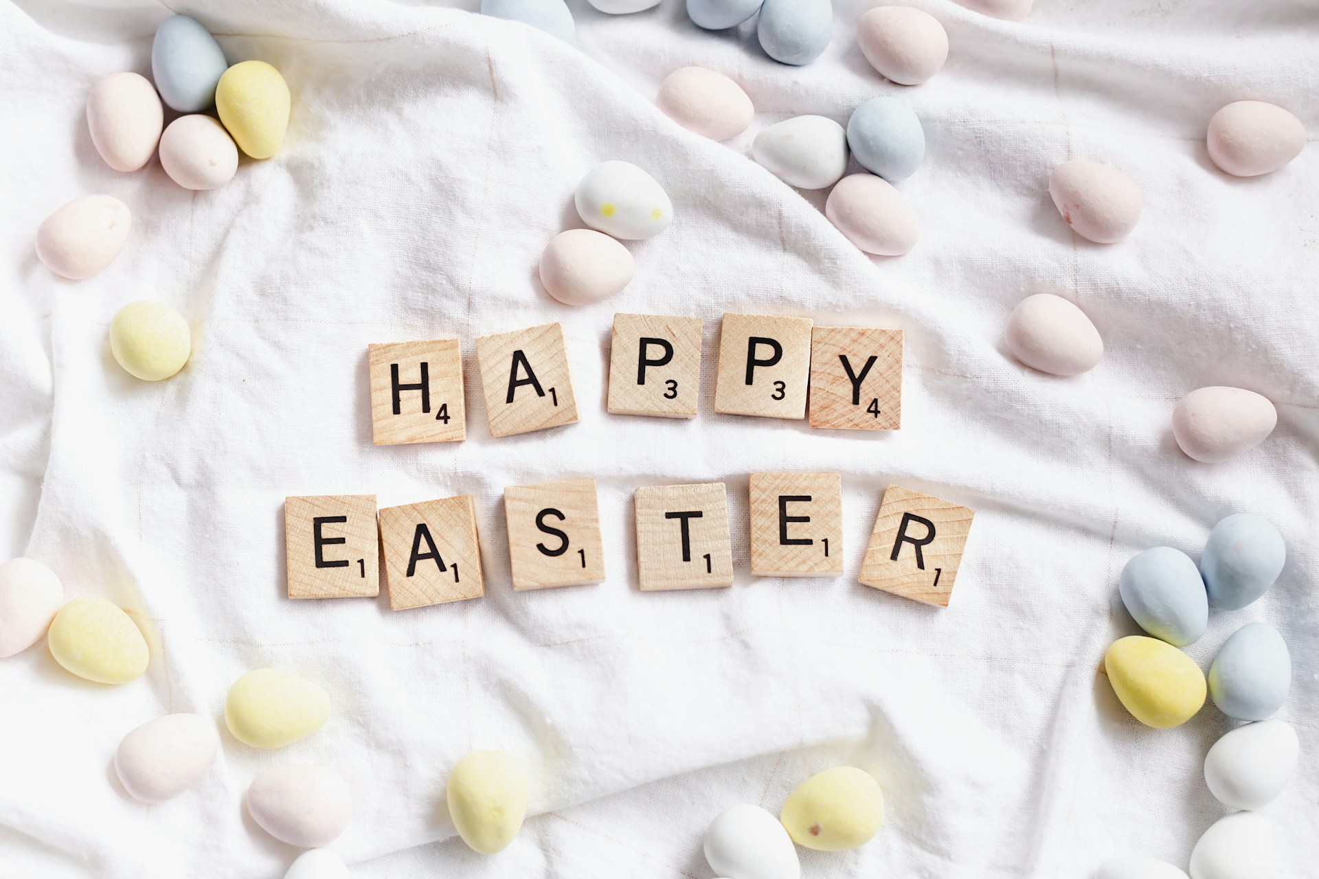 Happy easter text on white cloth with eggs